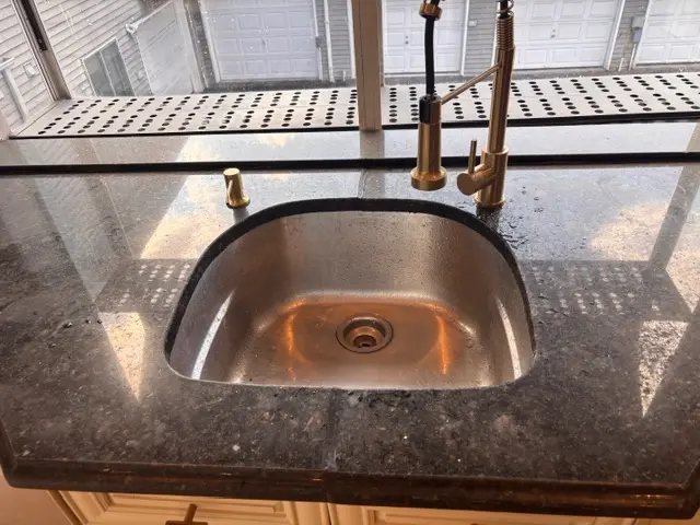 Gleaming granite countertop and sink after post-construction cleaning