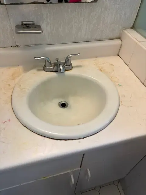 Dirty bathroom sink before residential cleaning